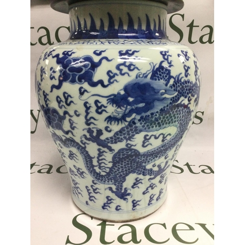 906 - A blue and white lidded vase depicting a dragon chasing a pearl, the hardwood lid having carved pier... 