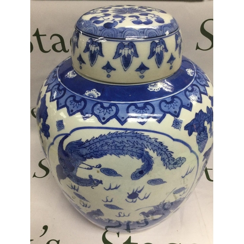 930 - A reproduction blue and white Chinese vase and cover depicting a dragon and a bird with a flaming pe... 