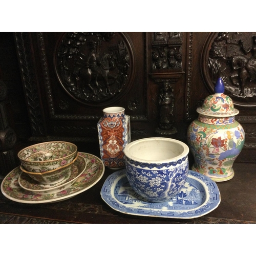 939 - A collection of Oriental ceramics comprising famille rose dishes and bowls, a blue and white vase de... 