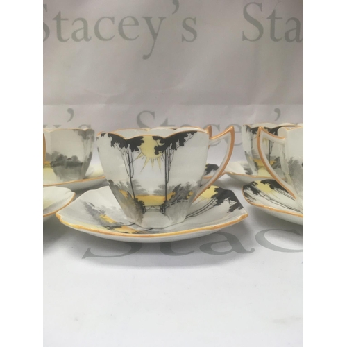 1002 - A set of eight Shelly cups and saucers Tall trees sunset pattern.