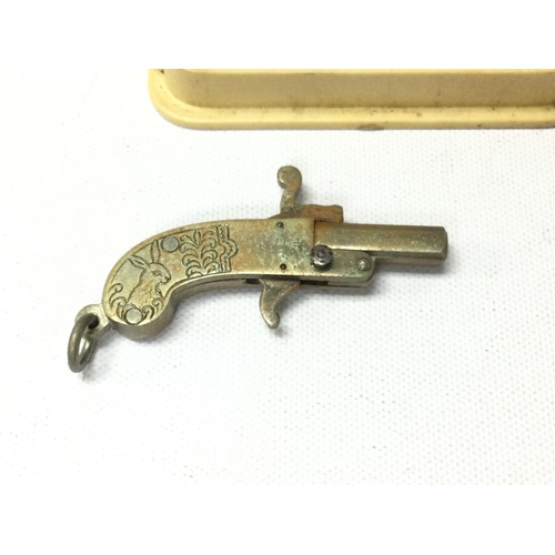 767 - Vintage miniature pin fire pistol cap gun charm with some caps.