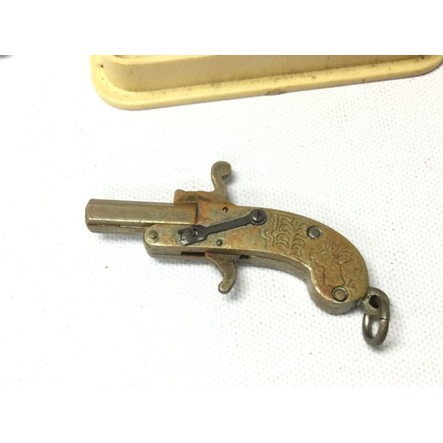 767 - Vintage miniature pin fire pistol cap gun charm with some caps.