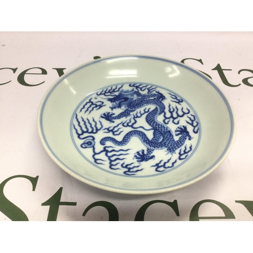 871 - A Chinese blue and white dish decorated with a dragon to the centre with six character marks to the ... 