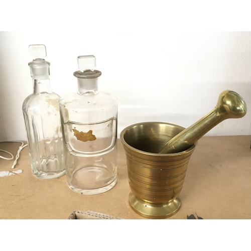 992 - A collection of chemist / apothecary brass mortar and pestle plus a mixed lot of 12 clear bottles of... 