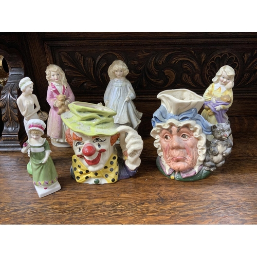 1059 - A collection of Royal Doulton ceramics to include figurines, and character jugs, and a large ceramic... 