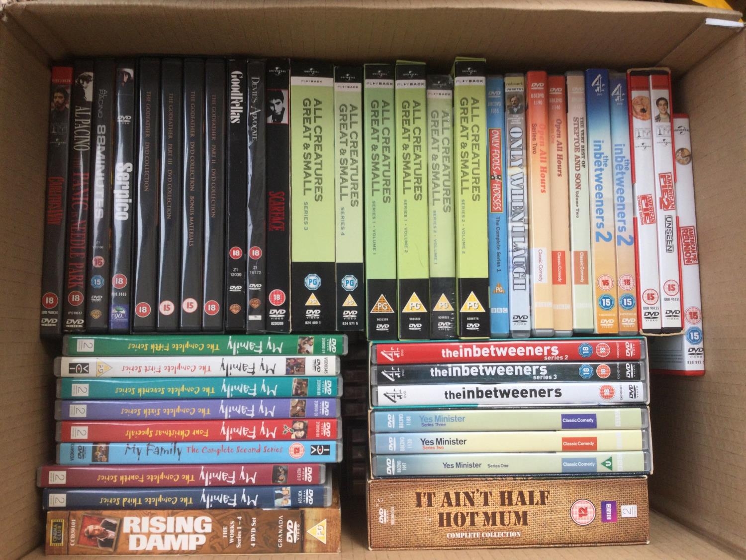 Three boxes of DVDs comprising many TV series and films.