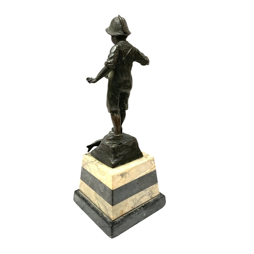 811 - A small bronze figure of a fisher boy mounted on a marble base. 27cm.