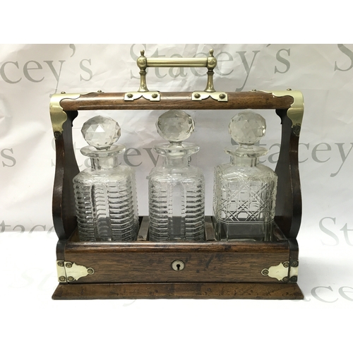 875 - An oak and silver plated three glass decanter tantalus ,37cm wide 35cm tall. This lot cannot be post... 