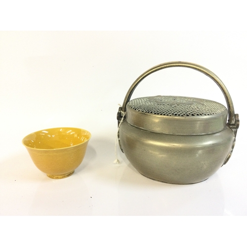 918 - A Chinese hand warmer and a yellow glaze bowl. 5 and 15 cm tall. This lot cannot be posted