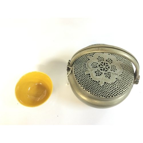 918 - A Chinese hand warmer and a yellow glaze bowl. 5 and 15 cm tall. This lot cannot be posted
