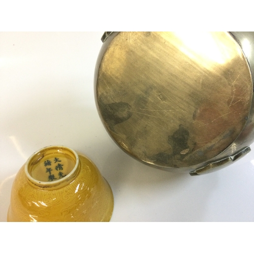 918 - A Chinese hand warmer and a yellow glaze bowl. 5 and 15 cm tall. This lot cannot be posted