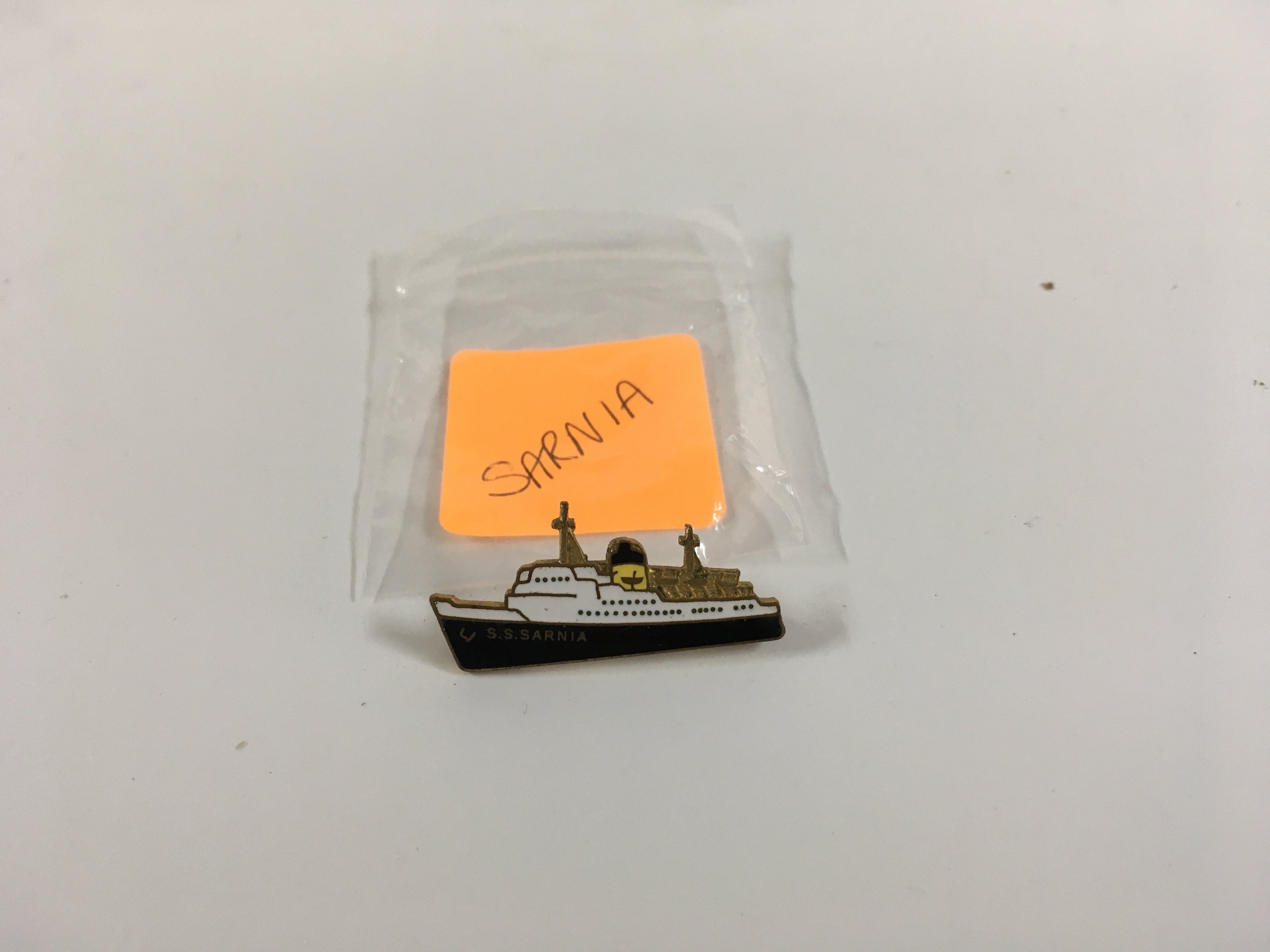 A collection of lapel pin ship badges consisting of an early ship shape ...