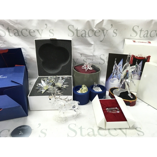 1027 - Swarovski boxed crystal glass figures including a stag, Masquerade Pierrot figure with stand and pla... 