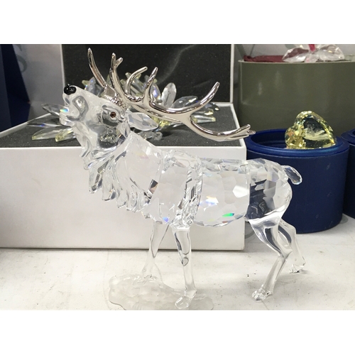 1027 - Swarovski boxed crystal glass figures including a stag, Masquerade Pierrot figure with stand and pla... 