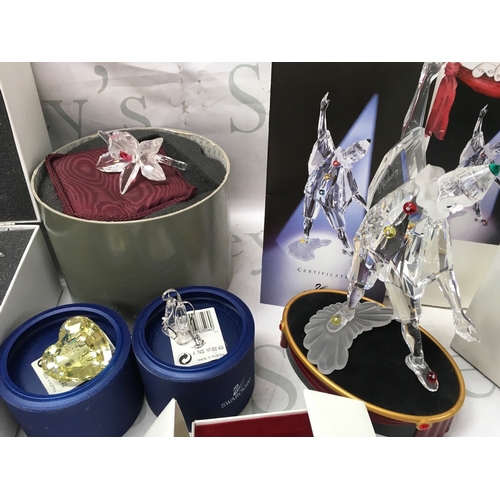 1027 - Swarovski boxed crystal glass figures including a stag, Masquerade Pierrot figure with stand and pla... 