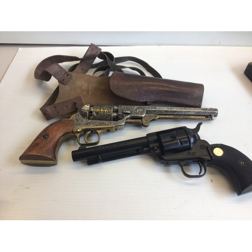 647 - Two Replica Vintage revolvers non firing ornaments. With a leather holster.
