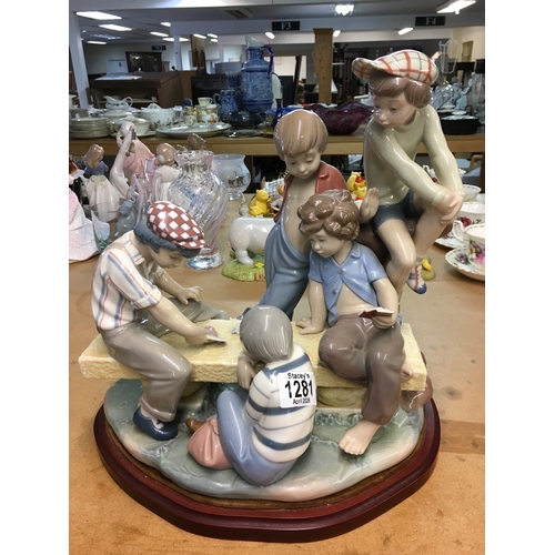 1281 - A large Lladro figure group of young boys playing cards on a bench. 30cm in height, not including wo... 