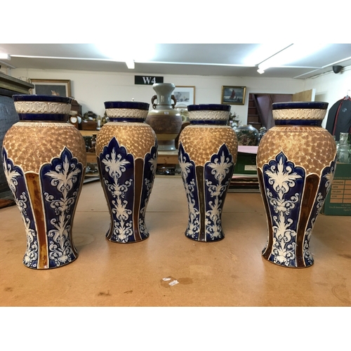 1299 - Four Royal Doulton Lambeth stoneware vases, decorated with stylised foliage. Some A/F. All 28cm in h... 