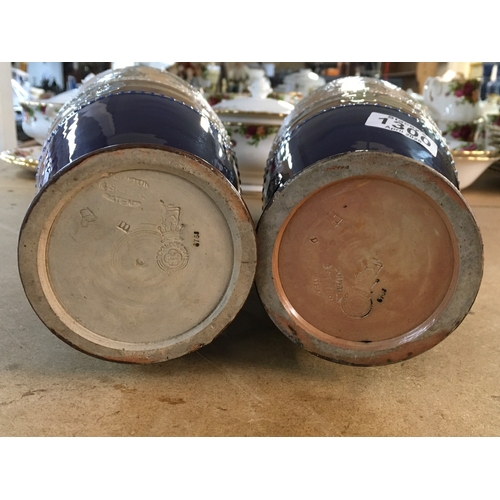 1300 - A pair Royal Doulton Lambeth Stoneware vases. 36cm in height. Decorated In flowers and foliage.