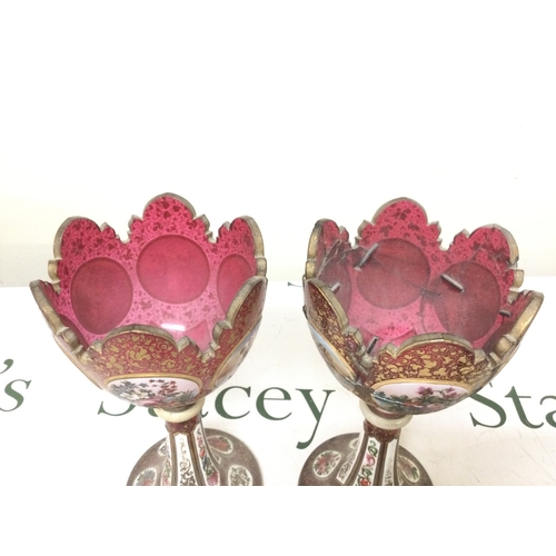 1398 - A pair of Victorian cranberry glass and enamel lustres (damaged). 26cm tall