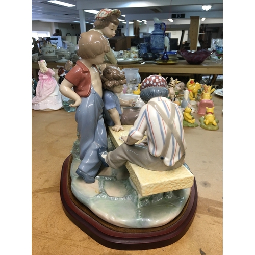 1281 - A large Lladro figure group of young boys playing cards on a bench. 30cm in height, not including wo... 