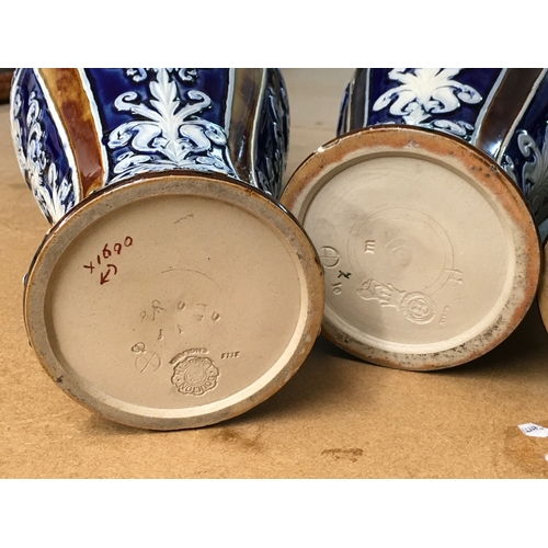 1299 - Four Royal Doulton Lambeth stoneware vases, decorated with stylised foliage. Some A/F. All 28cm in h... 