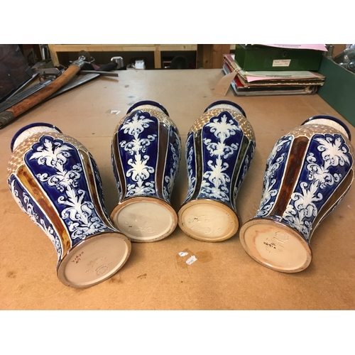 1299 - Four Royal Doulton Lambeth stoneware vases, decorated with stylised foliage. Some A/F. All 28cm in h... 