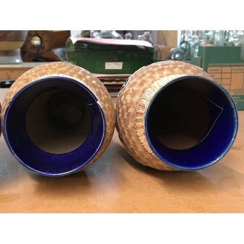 1299 - Four Royal Doulton Lambeth stoneware vases, decorated with stylised foliage. Some A/F. All 28cm in h... 