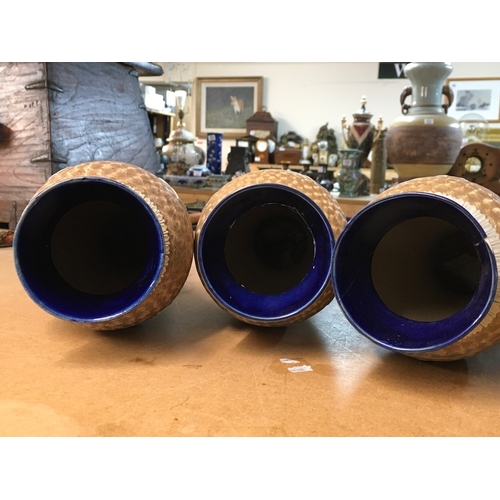 1299 - Four Royal Doulton Lambeth stoneware vases, decorated with stylised foliage. Some A/F. All 28cm in h... 