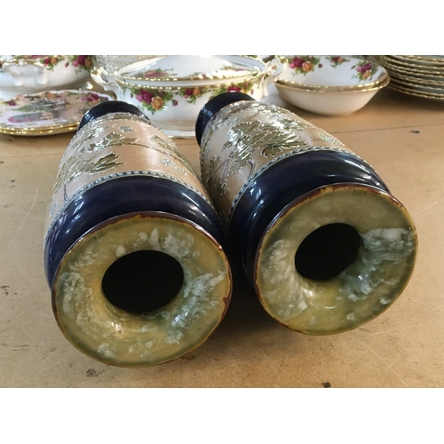 1300 - A pair Royal Doulton Lambeth Stoneware vases. 36cm in height. Decorated In flowers and foliage.