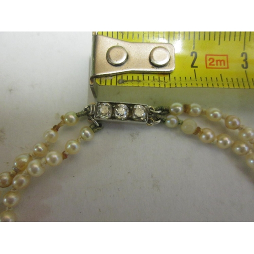 80 - Double strand pearl necklace with unmarked white and yellow gold clasp set with three diamonds