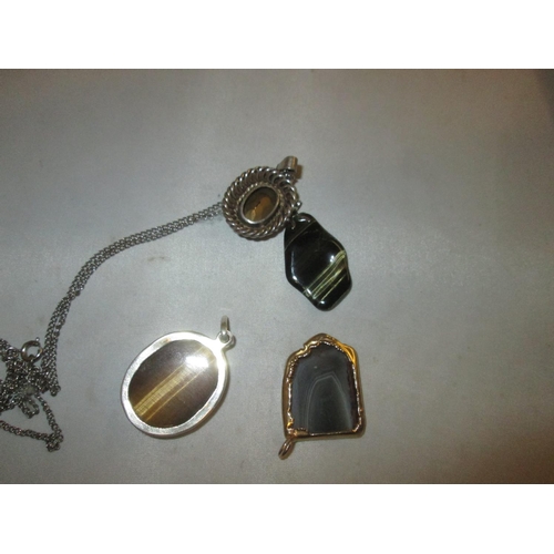 128 - 4 x hardstone pendants, set in silver and gold plate : Tigers eye, agate, coloured glass