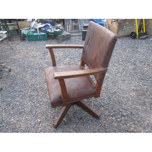 455 - Early 20th century oak and leather revolving office chair with makers mark, leather split on front