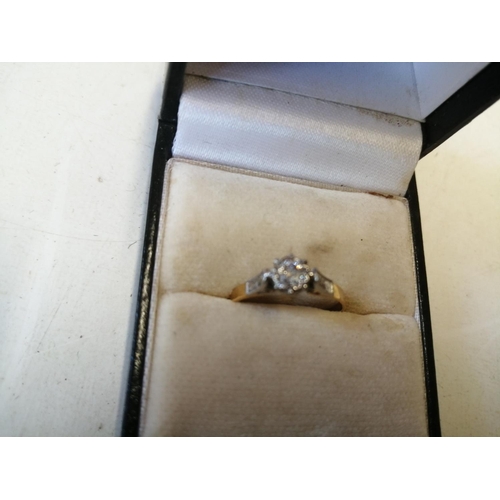 124 - 18 ct gold ring with solitaire diamond in raised platinum set with two further diamonds down the sha... 