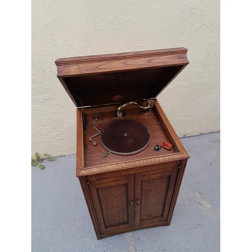 575 - Edephone floor standing wind up gramophone in oak case, working order with crank, case top needs att... 