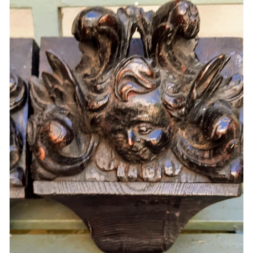 296 - A pair of late 17th early 18th century carved oak corbels carved angel faces mounted on later backpl... 