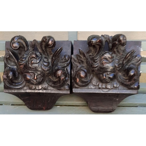 296 - A pair of late 17th early 18th century carved oak corbels carved angel faces mounted on later backpl... 
