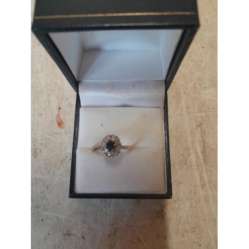 153 - Unmarked bust test 9 ct gold ring set with a single dark sapphire surrounded by diamonds size L, 2.6... 