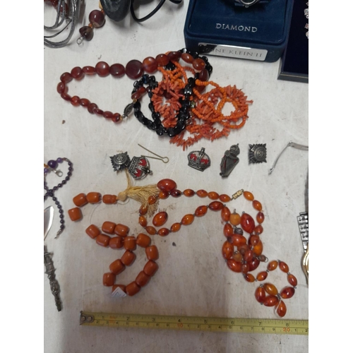 227 - Assorted costume jewellery : military cap badges, faux and reconstituted amber, watches, mobile phon... 