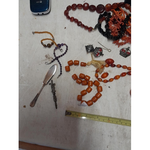 227 - Assorted costume jewellery : military cap badges, faux and reconstituted amber, watches, mobile phon... 