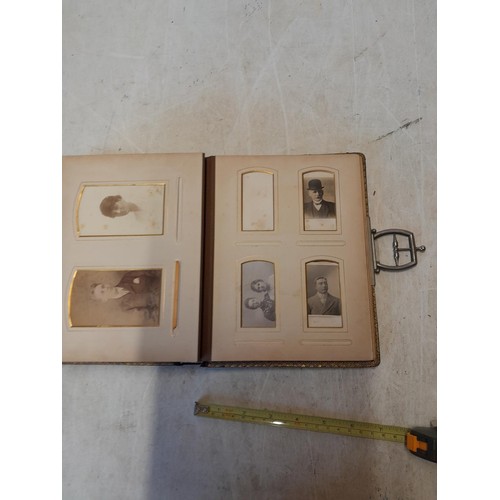 222 - A well filled early 20th century family photograph album, note spine damage