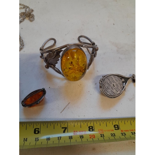 52 - Assorted silver and reconstituted amber jewellery including large revolving pendant, bangle etc.