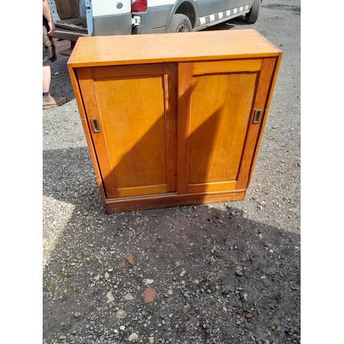 106 - Vintage pine sliding two door cupboard with recessed brass handles 110 cms x 108 cms x 44 cms