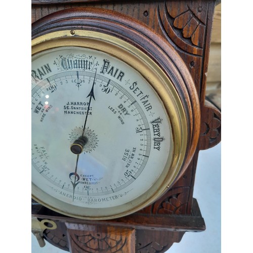 72 - Early 20th century carved oak case barometer with thermometer and clock by Harrop of Manchester