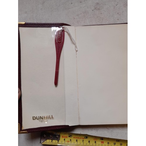 142 - Dunhill notebook in maroon leather case with original page marker