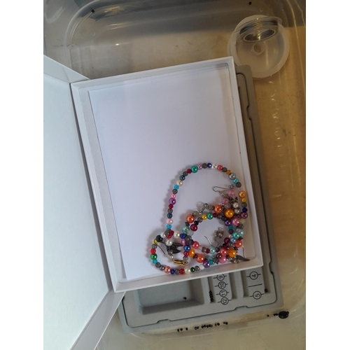 73 - Costume jewellery in a tiered plastic carrier