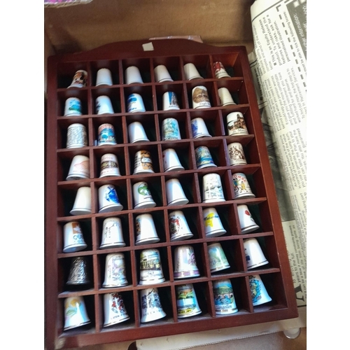 54 - Collectors porcelain thimble in display cases