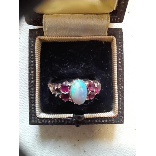 41 - Unmarked but test 9 ct gold ring set with opal and rubies, missing one stone size N 2.8 g in present... 