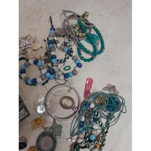 141 - Costume jewellery, beads enamel badges etc.