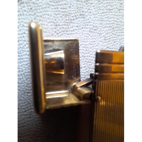 471 - A fine example of a Cartier ladies cigarette lighter in original box of issue, the engine turned dec... 